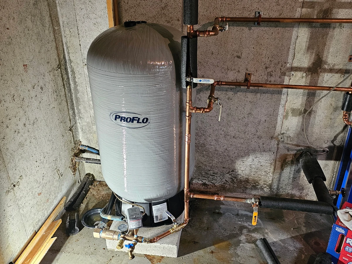 Well water pressure tank with copper supply manifold and shut-off valves installed by A.J. LeBlanc Heating in a Southern NH basement